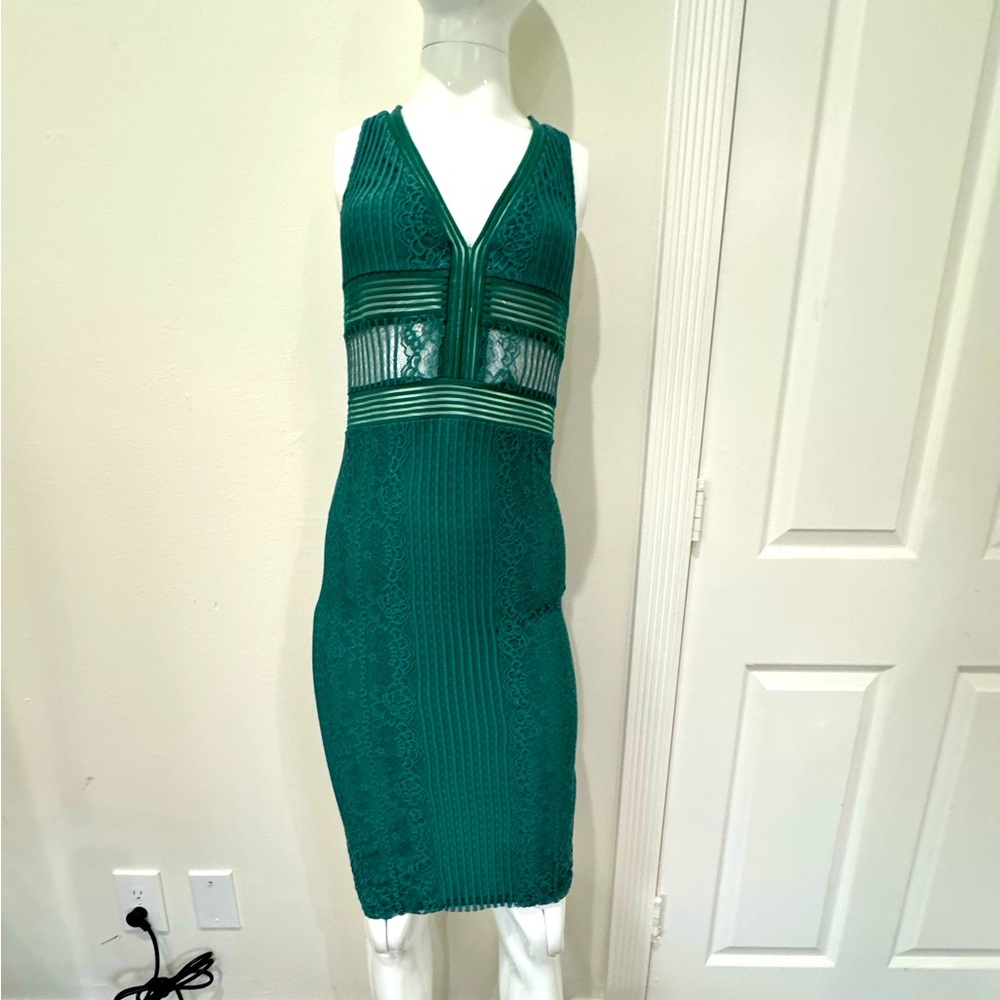 BEBE NWOT emerald green knee length peekaboo and lace dress. Small slit in back
